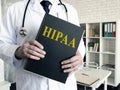 Doctor holds papers about HIPAA certification. Health Insurance Portability and Accountability Act.