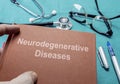 Doctor holds book on neurodegenerative Diseases in a hospital