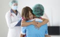 Doctor holds frightened little child girl in arms in clinic Royalty Free Stock Photo