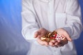 Doctor holds multi-colored pills and pack of different tablet blisters in hands. Panacea, life save service, prescribe medicament, Royalty Free Stock Photo