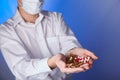 Doctor holds multi-colored pills and pack of different tablet blisters in hands. Panacea, life save service, prescribe medicament, Royalty Free Stock Photo