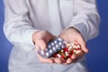 Doctor holds multi-colored pills and pack of different tablet blisters in hands. Panacea, life save service, prescribe medicament, Royalty Free Stock Photo