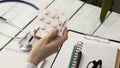 Doctor holds multi-colored pills and pack Royalty Free Stock Photo