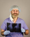 Doctor holds pictures of bones. Fracture and bone damage. Doctor examines radiographic snapshot of wrist. Surgeon