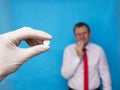 The doctor holds a pill in his hand for oral herpes, a man holds on to hers lip, herpes, pills against herpes, immunostimulating