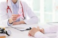 Doctor holds pink ribbon at appointment with patient Royalty Free Stock Photo