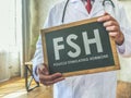 Doctor holds sign FSH Follicle stimulating hormone.