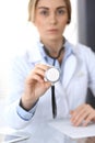 Doctor holds stethoscope head, closeup. Physician ready to examine and help patient. Medical help and insurance in