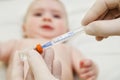 Doctor holds syringe to vaccinate baby