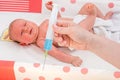 Doctor holds syringe to vaccinate newborn baby Royalty Free Stock Photo