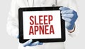 Doctor in holds a tablet with text SLEEP APNEA