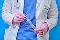 Doctor holds a test tube for analysis of coronavirus, hands closeup on a blue background. Concept of treating patients with