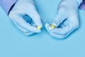 Doctor holds yellow pills in his hands. medical worker in gloves. pharmacology. blue background Royalty Free Stock Photo