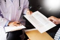 Doctor informing patient`s of diagnosis medical record from pape