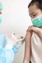 Doctor injecting flu or COVID-19 vaccine by injection into child girl body with a syringe to treat and produce immunity against Royalty Free Stock Photo