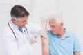 Doctor injecting senior patient in clinic