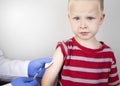 A doctor injects a vaccine into the boyÃ¢â¬â¢s shoulder. The concept of vaccination of children and the prevention of infectious