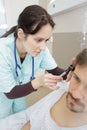 Doctor inserting hearing aid in mans ear Royalty Free Stock Photo