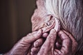 Doctor inserting hearing aid in senior patient ear Royalty Free Stock Photo