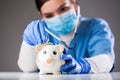 Doctor inspecting piggy bank with stethoscope