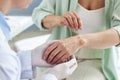 Doctor inspecting skin rash on hand of female patient in dermatology clinic