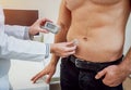 Doctor with an insulin pump connected in patient abdomen