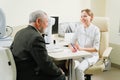 doctor interviews elderly man before being examined in ophthalmologist& x27;s office.