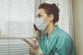 Doctor italian woman in medical mask, gloves and doctor`s suit closed her eyes and talking on a cell phone Royalty Free Stock Photo