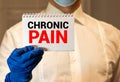 Doctor keeps a card with the name of the diagnosis chronic pain. Selective focus. Medical concept