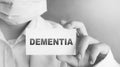 Doctor keeps a card with the name of the diagnosis - dementia. Selective focus. Medical concept