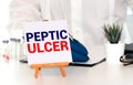 Doctor keeps a card with the name of the diagnosis - peptic ulcer. Selective focus. Medical concept