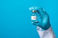 A doctor or lab technician in blue gloves holds a rabies vaccine with a place to text. Prevention in veterinary medicine. Rabies