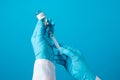 A doctor or laboratory technician holds a vial with a hepatitis B vaccine in his hand. With a place for text on a blue background