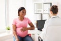 Doctor with laptop and pregnant woman at clinic Royalty Free Stock Photo