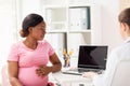 Doctor with laptop and pregnant woman at clinic Royalty Free Stock Photo