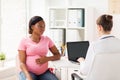 Doctor with laptop and pregnant woman at clinic Royalty Free Stock Photo