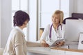 Doctor with laptop and pregnant woman in doctor`s office