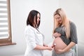 Doctor listening heart beat of baby in stomach. Royalty Free Stock Photo