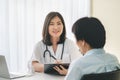 Doctor listening patient explain his symptom and notes to medical record Royalty Free Stock Photo