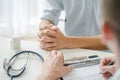 Doctor listening patient explain his symptom and notes to medical record