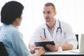 Doctor listening patient explain his symptom and notes to medical record