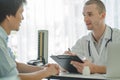 Doctor listening patient explain his symptom and notes to medical record