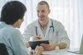 Doctor listening patient explain his symptom and notes to medical record Royalty Free Stock Photo