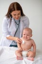 Doctor listening to the child heartbeat with a sterile stethoscope