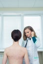 Doctor listening to patients chest with stethoscope in his office at the hospital Royalty Free Stock Photo