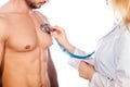 Doctor listening to young patient chest with stethoscope in his office at the hospital. Royalty Free Stock Photo