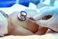 Doctor listens to the heart with a stethoscope new born baby