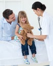 Doctor and little girl examining a teddy bear