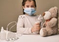 Doctor little girl in mask playing with a toy bear. Child doctor concept. Inhalation Royalty Free Stock Photo