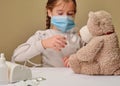 Doctor little girl in mask playing with a toy bear. Child doctor concept. Inhalation Royalty Free Stock Photo